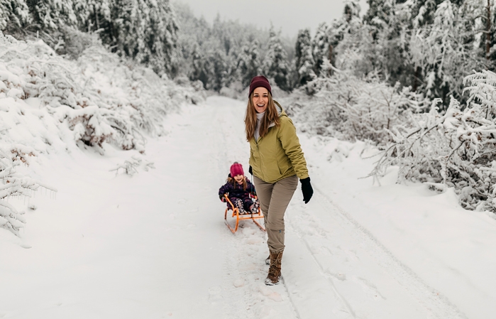 Woman pulling her child on a toboggan