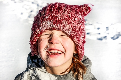 Kind mit roter Mütze im Schnee